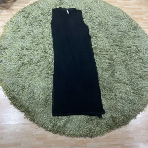 Svart ärmlös långklänning från FB Sister - Säljer en stilren svart ärmlös långklänning från FB Sister i storlek XS. Perfekt för både vardag och festliga tillfällen. Klänningen har en enkel och elegant design som gör den lätt att matcha med olika accessoarer.