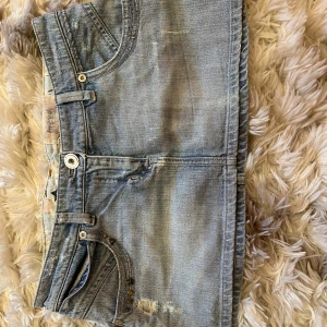 Vintage minikjol - Vintage minikjol i jeansmaterial. Midjemått är 41cm, och längd i framsida är 25-27cm, och längd bakifrån är ungefär 29cm. 