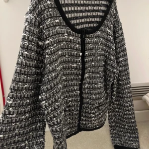 Svartvit kofta - Fin svartvit kofta med dragkedjor på två ställen utöver där man stänger den som visas på bilderna. Använd endast 1 gång men köpt på Sellpy så osäker på hur använd den va innan💕 Storlek 40 men passar mig som är en S!