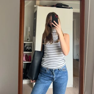 Turtleneck randigt linne - Vitt och mörkblå randigt linne med turtleneck. 100% bomull. Trendigt med en kappa över!