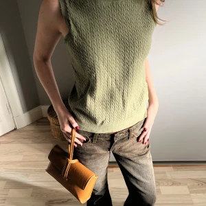 Olivgrön stickad ärmlös topp från Zara - Säljer en superfin olivgrön stickad topp från Zara. Den är ärmlös och snygg med en kavaj över!! Passar storlek XS-M