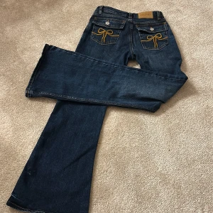 Lågmidjade monki jeans  - Säljer dessa snygga jeans från monki pga för små i midjan. Dessa har super fina detaljer på fickorna med rosetter 🎀. De har en fin mörkblå vintage färg som gör de så fina att ha på sig i skolan, hemma och på fest💞