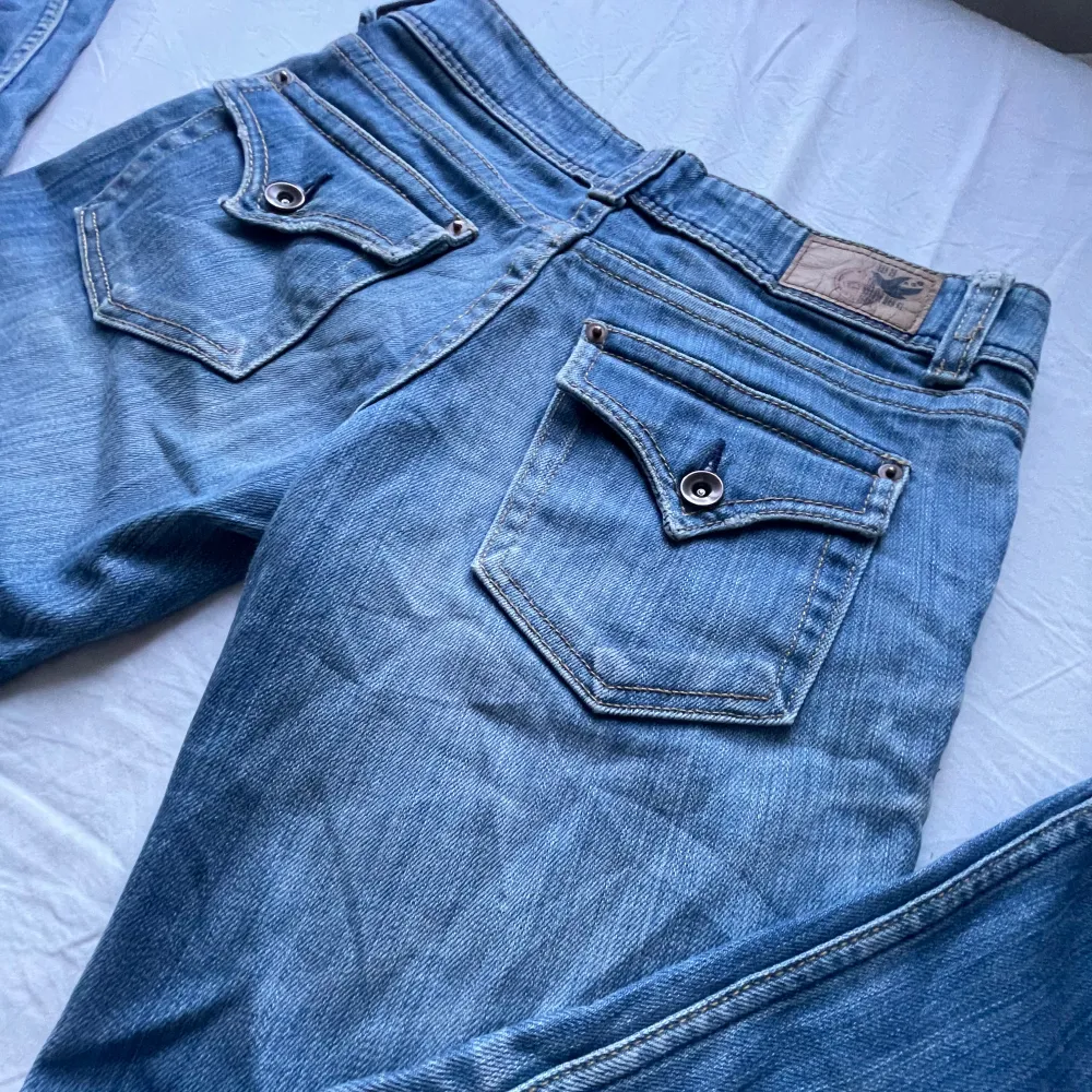 Säljer ett par så snygga lågmidjade bootcut jeans. Midjemåttet: 34 cm rakt över, innerbensläng: 77 cm, gren: 18 cm. Lite slitage längst ner men annars är dem i fint skick. Obs första bilden är från förra ägaren.💕. Jeans & Byxor.