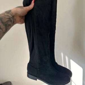Höga boots - Jag är 153cm och dessa går upp till mina knäskålar. Liten dragkedja nere vid foten (se bild) Svarta