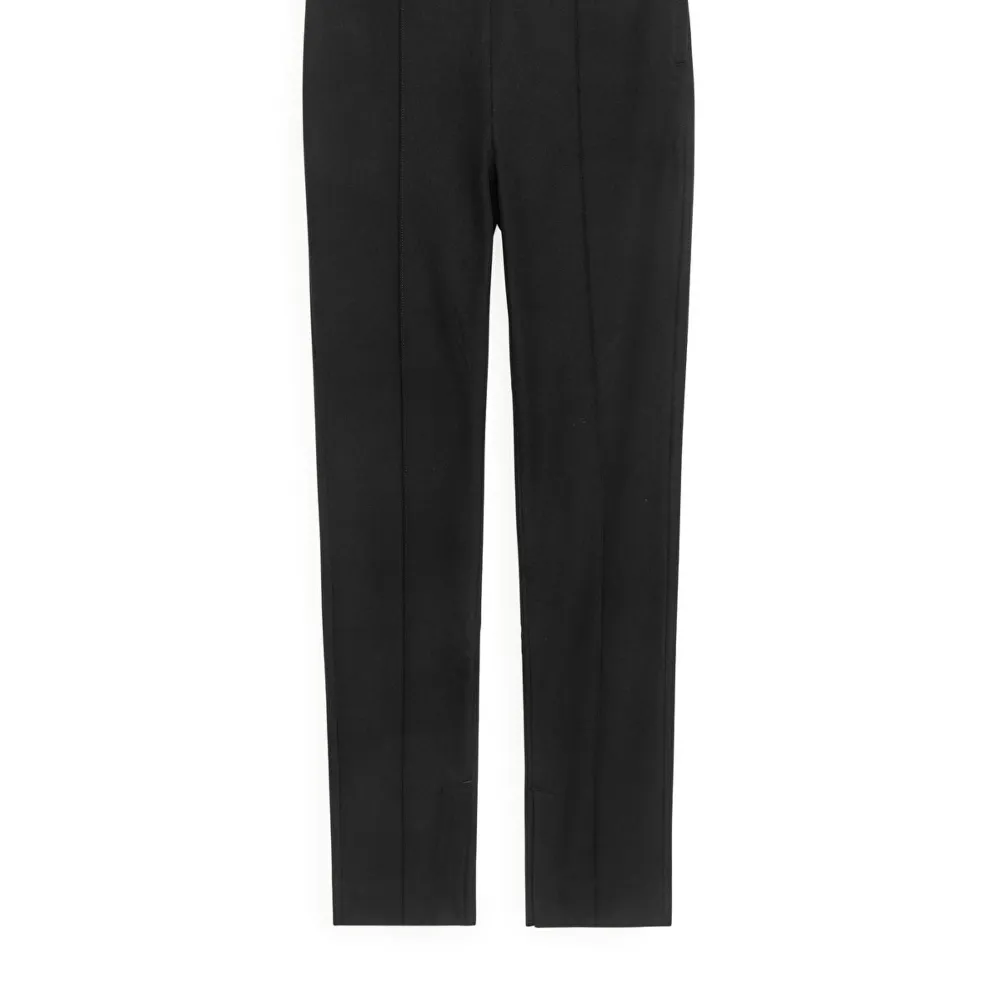 Kostymbyxor i bomull slim fit från Arket, i storlek 44. Resår i midjan och snygg slits längst ner. Farkut & Housut.