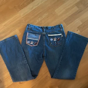 Bootcut blomjeans - Supersöta bootcut, midrise jeans med blomdetaljer i storlek ca 28. Jeansen är i nyskick, priset kan diskuteras 