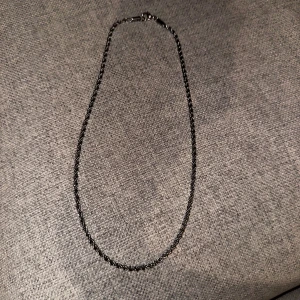 Ett silver halsband med skruv  - En perfekt accessoarer som passar till alla kläder 