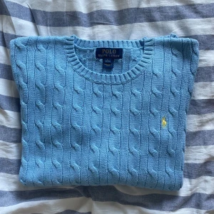 Ralph Lauren tröja - Säljer en Ralph Lauren kabelstickad tröja i nyskick. Tröjan är i storlek L (ungdom/junior) vilket motsvarar 14-16 år. Nypris 1200:- Hör av er vid funderingar📩