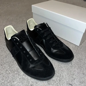 Maison Margiela  - Tvär feta Maison margiela sneakers i hel svart färg. De är storlek 42, men vill man att dem ska sitta riktigt bra passar de bättre på 43. Box kommer med! Kan även skickas med vita snören! Fråga hur de ser ut så skickar jag bild på de så kan du välja 