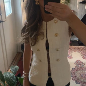 Vit topp med guldknappar - Snygg vit topp med stora guldknappar framtill. Passar både till vardags och fest. Säljer då den är lite för stor för mig💖