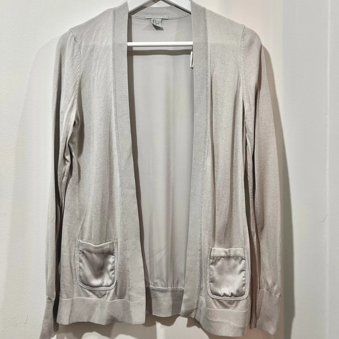 Grå kofta med fickor och silverderaljer