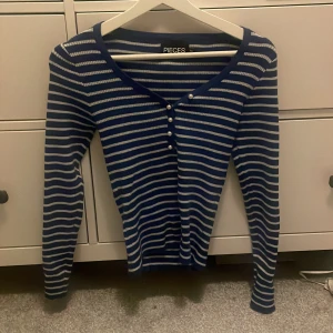 Randig tröja  - Gullig randig tröja ifrån Pieces, pärlknappar som går att knappa upp. Väldigt stretchig och mjuk i materialet. Endast använd 2 gånger. Storlek M. Skriv för mer bilder