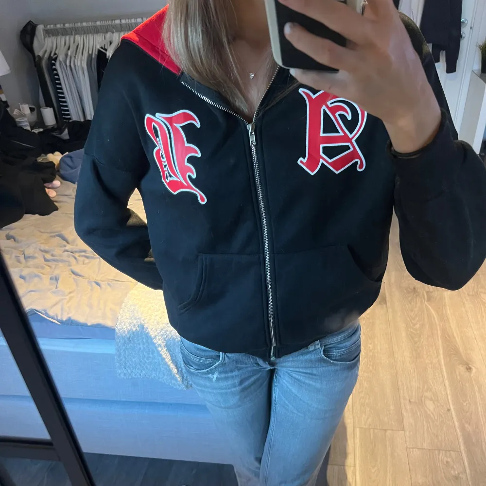 Säljer en cool svart hoodie från Shein med röd insida i luvan och stora bokstäver i rött och vitt på framsidan. Den har dragkedja och är perfekt för en avslappnad stil. Passar bra till jeans eller leggings. Perfekt för höst och vår!. Hoodies.