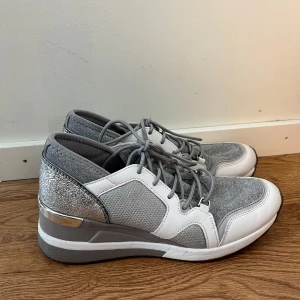 Michael Kors Liv Sneakers, silver, storlek 38.5 - Silvriga sneakers från Michael Kors, ”Liv”, i storlek 38,5. Skorna är i mycket fint skick och sparsamt använda. Läder och textil. Gummisula. 