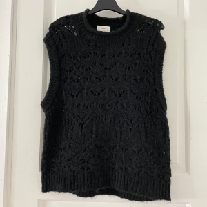 Svart stickad tröja från Object - Säljer en snygg svart stickad väst från Object i storlek S. Västen har ett fint mönster och kort armad. Aldrig använd då jag tycker halsen är för hög. 