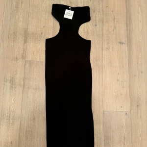 Svart långklänning från Public Desire - Snygg svart långklänning från Public Desire i ett elegant och stilrent snitt. Perfekt för festliga tillfällen eller en utekväll. Klänningen är ärmlös och har en tight passform som framhäver figuren. Ett måste i garderoben för den som älskar klassisk stil!