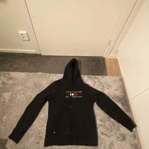 Jag säljer en svart Tommy Hilfiger hoodie för 249 kr i storleken Small.