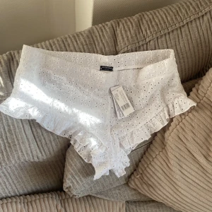 Vita spets shorts från Calzedonia - Säljer ett par superfina vita shorts från Calzedonia i nytt skick. De är gjorda av bomull med vacker spetsdetalj och volangkant. Perfekta för sommardagar eller en avslappnad dag på stranden. Storlek är dam S. Passa på att fynda dessa söta shorts! 🌸