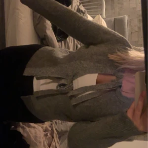 Grå ribbad kofta - Säljer en mysig grå ribbad kofta med knytband i midjan. Perfekt för höst och vinter, den har raka ärmar, köpt från Nelly men märket är pieces! Aldrig använd