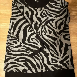 Zebramönstrad tröja från Blue & Blossom - Säljer en supercool zebramönstrad tröja från Blue & Blossom i storlek S men passar även xs och troligtvis M.  Den är svart och grå med långa ärmar och en normal passform. Perfekt för att sticka ut lite extra i höst och vinter! 🖤pris kan diskuteras