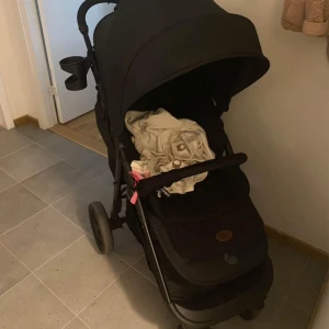 Beemo barnvagn - Svart barnvagn med en stor sufflett och en kopp- eller flaskhållare på handtaget. Vagnen är i ny skick och köpte in den för nypris 3000:- i juli så därav halva priset pga att jag behöver bli av med den så fort som möjligt! Snabb affär prioriteras