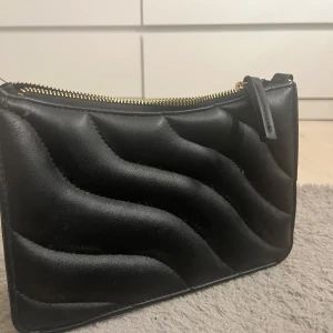 Svart habndväska med guld dragkedja🪩 - Snygg mönstrad svart handväska med guldig dragkedja🪩❤️🥂