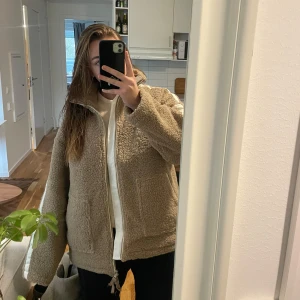 Beige teddyjacka - Mysig beige teddyjacka med dragkedja, perfekt för vintern!!! Jackan har en något overzised passform. Helt ny med prislappen kvar!