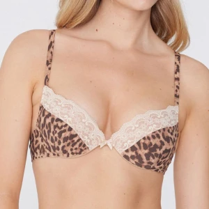 Leopardmönstrad bh med spetsdetaljer - Snygg leopardmönstrad bh med beige spetsdetaljer längs kanten. Perfekt för att lägga till lite vild stil i din garderob. Den har justerbara axelband för bästa passform. Typ helt oanvänd❤️