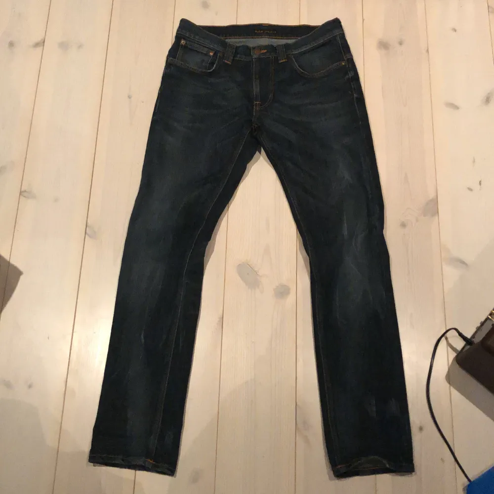 Säljer ett par mörkblå jeans från Nudie Jeans i bra skick. De har en klassisk femficksdesign och är tillverkade i slitstarkt denim. Perfekta för både vardag och fest! 🕺pris kan diskuteras W31 L32 på bredden är dem små i storleken jag har i vanliga fall 29. Jeans & Byxor.