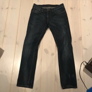Mörkblå jeans från Nudie Jeans - Säljer ett par mörkblå jeans från Nudie Jeans i bra skick. De har en klassisk femficksdesign och är tillverkade i slitstarkt denim. Perfekta för både vardag och fest! 🕺pris kan diskuteras W31 L32 på bredden är dem små i storleken jag har i vanliga fall 29
