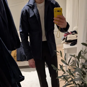 Mörkblå overshirt från John Henric i M - Säljer en stilren mörkblå overshirt från John Henric i bra skick. Den har långa ärmar och knappar framtill samt två bröstfickor med knappar. Perfekt för höst och vår, kan bäras som jacka eller skjorta. Passar både till vardags och lite finare tillfällen. Storlek M. Modell på bilden är 183 cm och 77kg.