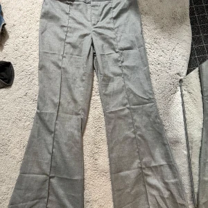 Grå lågmidjade kostymbyxor - Lågmidjade byxor från H&m i som jag knappt använt, dock är dom uppsprättade så de är lite trådiga nere vid benet (se bilder)
