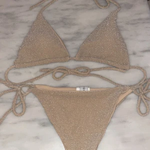 Glittrig bikini från Venderbys - Glittrig guldig bikini från Venderbys i storlek S. Aldrig använd så väldigt fint skick! Nypris ca 400kr. 