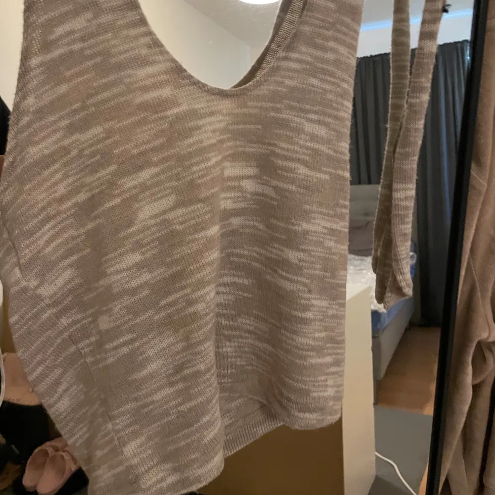 Säljer en superfin beige stickad linnetopp från H&M. Den har en snygg knytning i ryggen och är perfekt för både vardag och fest. Toppen är i ett mjukt och bekvämt material som passar perfekt till sommaren. Ett måste i garderoben! 🌟. Toppar.