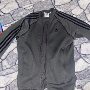 Grå adidas sst zip up i riktigt bra skick. Använd ett par gånger bara. Storlek S