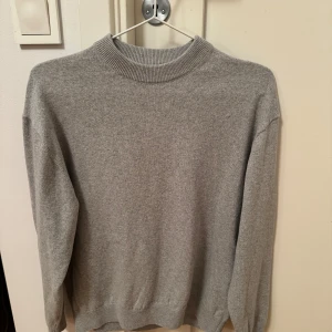 Grå tröja i bra skick - Säljer en stilren grå tröja i bra skick. Säljer pågrund av att den inte passar längre. Tröjan är i stort sett aldrig. Köpte tröjan utomlands vilket ledde till att jag inte kunde lämna tillbaks plagget. Funderingar kring plagget? Kontakta mig enkelt, priset går att diskuteras.