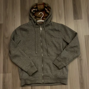 Burberry Zip Hoodie - Säljer nu min burberry zip för den inte används längre. Inga defekter eller liknande alls och tags, påsar osv följer självklart med. Hör gärna av dig vid fler frågor eller behov av andra bilder.