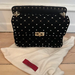 Svart Valentino Rockstud spike väska suede - Säljer min så fina Valentino Rockstud spike väska i materialet suade/sammet. Den är nästan i nytt skick då den bara blivit använd ett få tal gånger. Den köptes i butiken Max-B i Spanien. Skriv gärna vid funderingar💗.