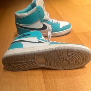 Turkosa/ljusblå basket sneakers - Säljer ett par snygga turkosa och vita basket sneakers i storlek 40. De har en klassisk hög modell med snörning och den ikoniska Air-loggan. Perfekta för både vardag och träning. Skorna är i mycket bra skick!