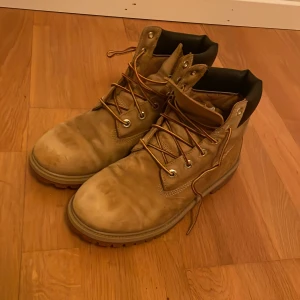 Beige boots från Timberland - Säljer ett par klassiska beige Timberland boots i bra skick. De har snörning och är perfekta för höst och vinter. Tillverkade i slitstarkt skinn med en robust sula som ger bra grepp. Perfekta för både stad och natur!