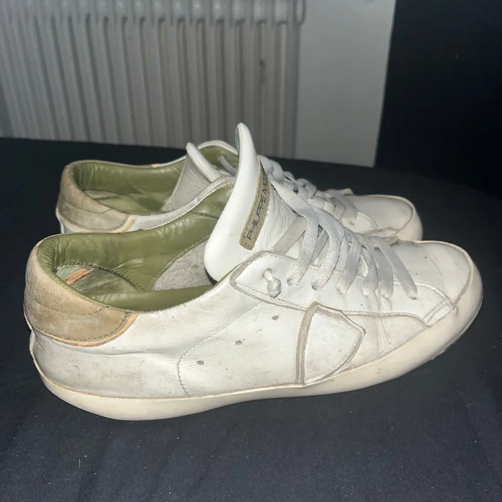 Säljer ett par vita sneakers från Philippe Model i bra skick. Skorna har en klassisk design med snörning och en bekväm passform. De är tillverkade i skinn och har en diskret logga på plösen. Perfekta för vardagsbruk och ger en perfekt look. Kengät.