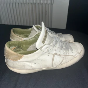 Vita sneakers från Philippe Model - Säljer ett par vita sneakers från Philippe Model i bra skick. Skorna har en klassisk design med snörning och en bekväm passform. De är tillverkade i skinn och har en diskret logga på plösen. Perfekta för vardagsbruk och ger en perfekt look