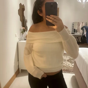 Vit offshoulder tröja från Vero Moda - Säljer en superfin vit offshoulder tröja från Vero Moda. Den är perfekt för både höst och vår med sin mjuka och bekväma passform. Tröjan har långa ärmar och en bred krage som ger en snygg look. Passar perfekt till både jeans och kjol!
