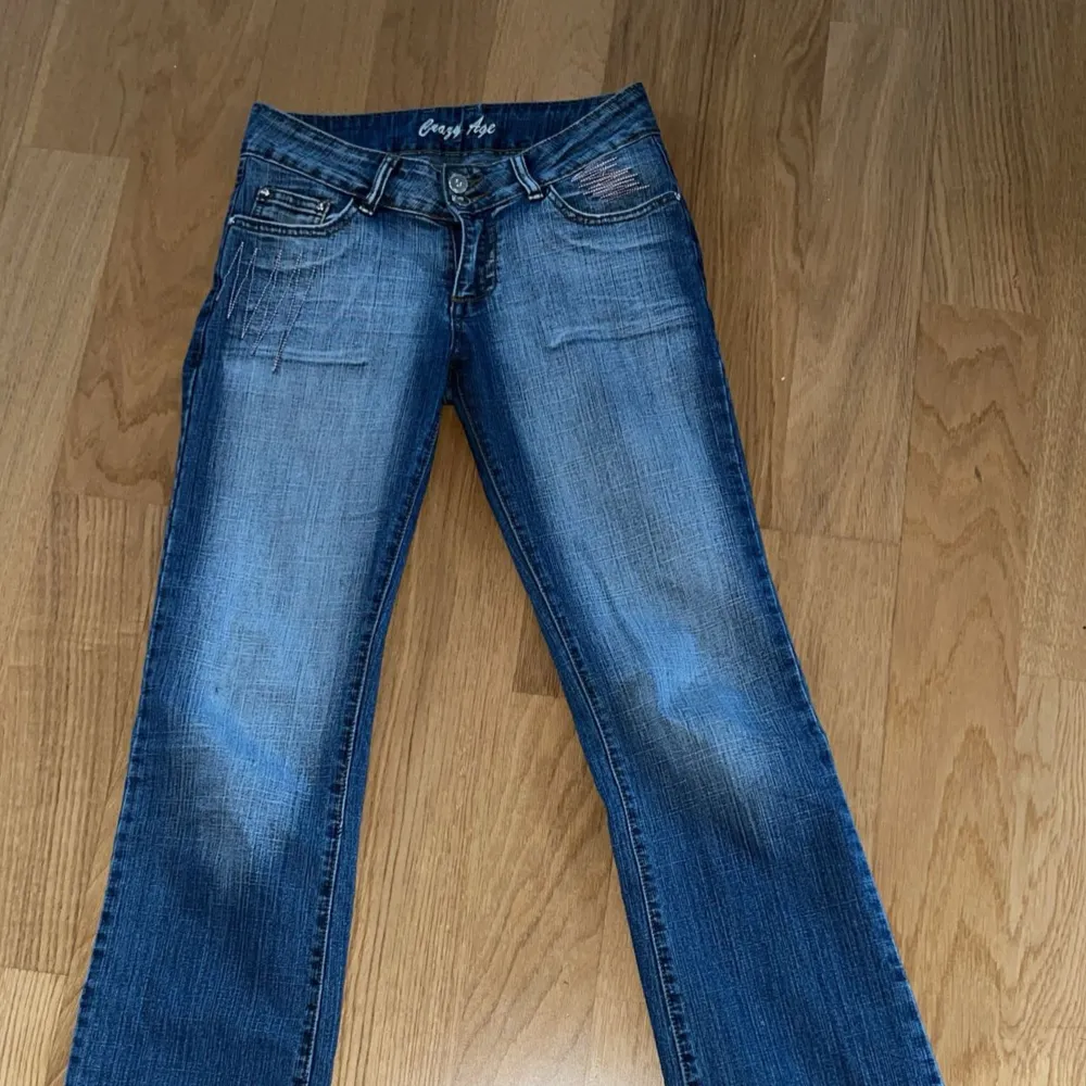 Säljer ett par snygga blå bootcut jeans från Crazy Age. De har en cool broderad detalj på bakfickan och är i perfekt skick. Säljer då de inte passar mig längre😢Mått: Midjan rakt över 35cm, innerben 80cm, ytterben 103cm, från gylf till midjekanten 20cm. Jeans & Byxor.