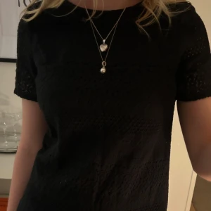 Svart spetsblus - Snygg svart blus i spetsmaterial med korta ärmar. Perfekt för både vardag och festliga tillfällen. Blusen har en elegant och tidlös design som passar till det mesta. Kombinera med jeans eller kjol för en komplett look. 💗