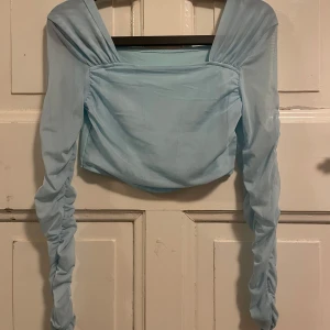 Blå topp - Jag säljer denna blåa toppen, den är köpt begagnat men är från shein.🩵