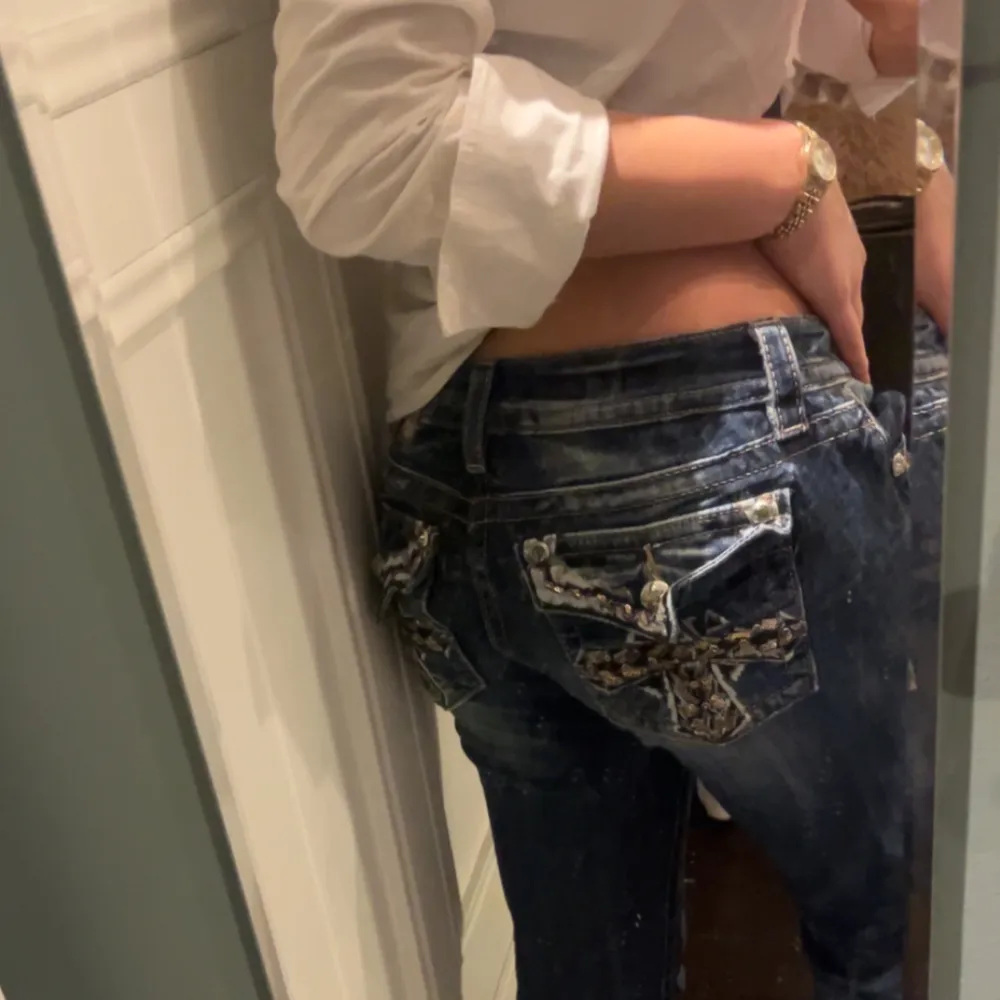 Säljer ett par snygga blå  Miss me jeans med unika broderade detaljer på bakfickorna. De är lågmidjade och har en normal passform. Perfekta för en avslappnad stil med en twist. Passar bra till både vardag och fest!. Jeans & Byxor.