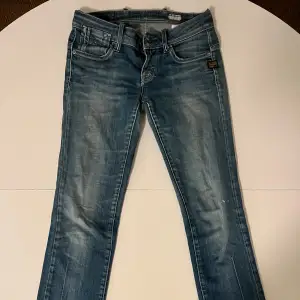 Säljer ett par snygga blå jeansbyxor i bra skick. Dem är låg midjade och är igen g-star raw.  De har inga defekter och är straight leg🩷 skriv för mått🩷