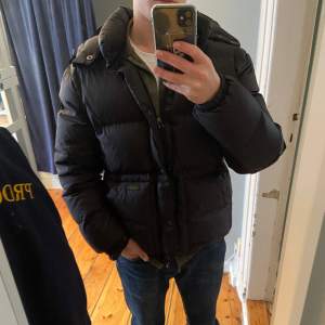 Säljer en klassisk svart dunjacka från Polo Ralph Lauren som är använd men i mycket fint skick. Storleken är M men kan även passa S. Modell på bilden är runt 180cm:) Pris kan diskuteras🥂