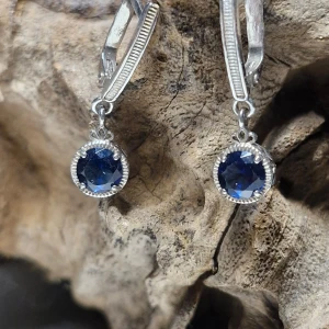 Silverörhängen med blå stenar - Snygga silverörhängen med gnistrande blå stenar. De har en elegant design med en säker låsmekanism. Perfekta för att ge en touch av färg till din outfit, oavsett om det är till vardags eller fest. 💙